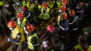 Moroccan emergency services teams carry five-year-old Rayan Oram to an ambulance after pulling him from a well shaft he fell into on February 1, in the remote village of Ighrane in the rural northern province of Chefchaouen on February 5, 2022. – Moroccan rescue crews found the five-year-old boy dead at the bottom of a well late on Februay 5, in a tragic end to a painstaking five-day operation that has gripped the nation. (Photo by Fadel SENNA / AFP) (Photo by FADEL SENNA/AFP via Getty Images)