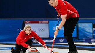 Norway's Magnus Nedregotten (R) and Norway's Kristin Skaslien curl the stone during the mixed doubles semifinal game