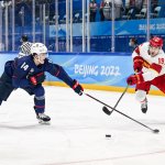 Brock Faber of Team USA and Wei Zhong of Team China battle for the puck at the men's ice hockey preliminary round match during the 2022 Winter Olympics in the National Indoor Stadium, Feb. 10, 2022, in Beijing, China.