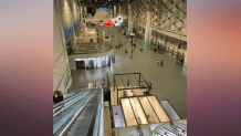 People move about a main hallway of the International Broadcast Center in Beijing during the Winter Olympics, Jan. 31, 2022.