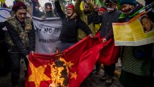 Exiled Tibetans burn a Chinese flag during a protest against Beijing Winter Olympic Games in New Delhi, India, Feb. 4, 2022.