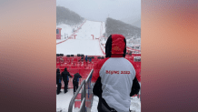 A person looks up a ski slope in the mountains outside of Beijing at the Winter Olympics, Feb. 13, 2022.