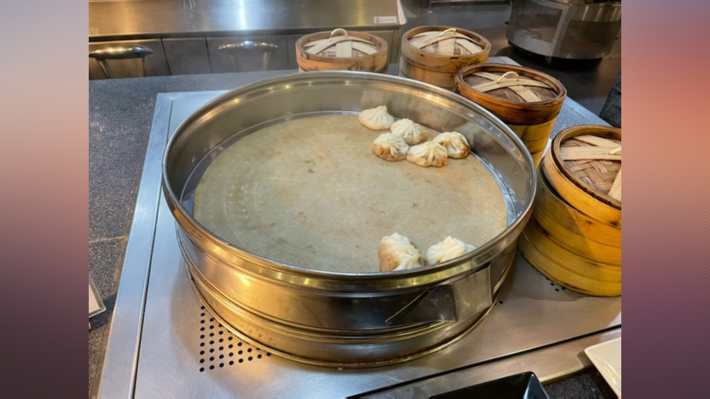 A nearly empty dumpling steamer sits on a buffet table in a dining hall in Beijing at the Winter Olympics, Feb. 8, 2022.
