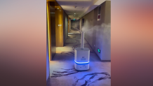 An air-sanitizing robot rolls down a hotel hallway in Beijing during the Winter Olympics, Feb. 13, 2022.