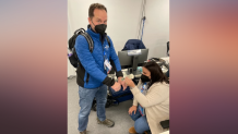NBC 7 anchor Steven Luke (left) gets some help with dry hands from Miami Telemundo colleague Yari Domenech Del Valle, (right) in Beijing at the Winter Olympics, Feb. 10, 2022.