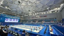 Spectators watch competitors inside the Curling Arena at the National Aquatics Center, also known as the "ice cube," at the Winter Olympics in Beijing, Feb. 2, 2022.