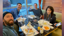 A group of four NBC employees, including NBC 7 anchor Steven Luke (upper right corner), gather for breakfast in a dining hall in Beijing at the Winter Olympics, Feb. 8, 2022.