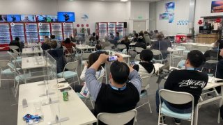 Spectators gather in a room to watch the Opening Ceremony of the Winter Olympics in Beijing, Feb. 4, 2022.