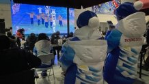 A group of onlookers watch the Opening Ceremony of the Winter Olympics from a big screen TV in Beijing, Feb. 4, 2022.