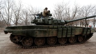 A service member is seen atop of a tank while pro-Russian troops gather in the separatist-controlled settlement of Mykolaivka (Nikolaevka), as Russia’s invasion of Ukraine continues, in the Donetsk region, Ukraine March 1, 2022.