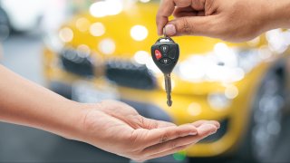 Hand of business man gives the car key to a new buyer. FILE.