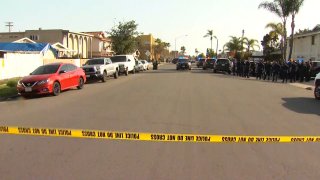 San Diego Police officers outside an apartment complex where a person suspected of stabbing a person in the neck may be.