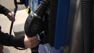 A person lifts a gas pump in this undated image.