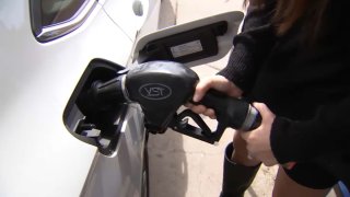 A woman pumps gas into her vehicle in this undated image.