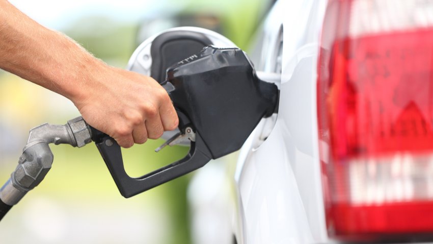 FILE person holding onto a gas pump as they fill up.