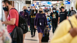 Flight attendants wearing protective masks walk through Hartsfield-Jackson Atlanta International Airport in Atlanta, Georgia, on Wednesday, April 7, 2021.