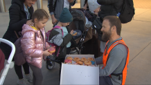 Pavel Volkov, a volunteer, greets Ukrainian children crossing the border with snacks