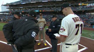 Twin brothers, Taylor Rogers of the Padres and Tyler Rogers of the Giants, exchange lineup cards at home plate before a game on April 11, 2022.