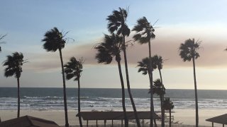 a haze of smoke over the ocean in Oceanside, California. The smoke is from a wildfire in Orange County