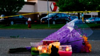Flowers and candles lay outside the scene of a shooting at a supermarket, in Buffalo, N.Y., Sunday, May 15, 2022.