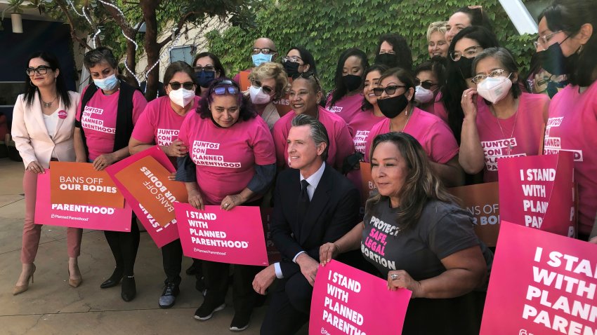 California Gov. Gavin Newsom poses with workers and volunteers on Wednesday, May 4, 2022, at a Planned Parenthood office near downtown Los Angeles.