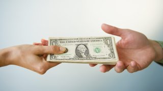Close up of man's and woman's hands holding banknotes, studio shot