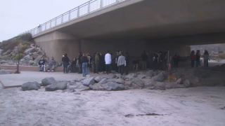 Loved ones gather to mourn two 19-year-olds killed when a car plowed through a barrier and came to a stop on Torrey Pines State Beach on April 25, 2022.