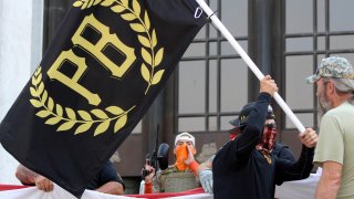 FILE - In this Sept. 7, 2020, file photo, a protester carries a Proud Boys banner, a right-wing group,