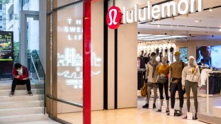 A man waits outside a Lululemon store in Hong Kong