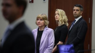 Amber Heard stands with her lawyers