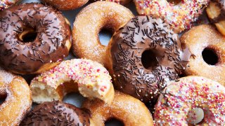 A mixture of iced chocolate and regular ring doughnuts.