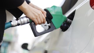 An undated file photo of a person pumping gas into a car.