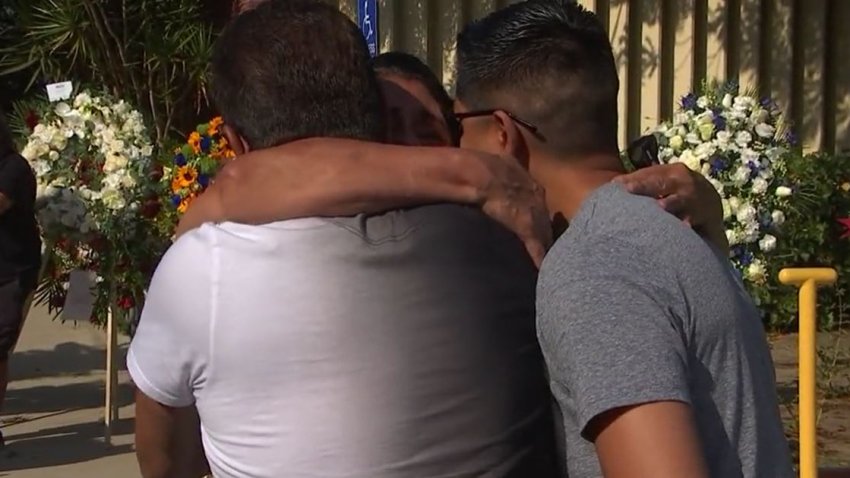 Family members embrace at a memorial for two slain El Monte police officers killed in a shootout on Tuesday, June 14, 2022.