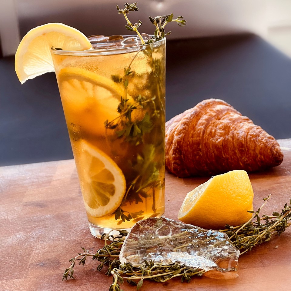 Izola's Hot Potion peppermint tea is featured next to one of their 96-layer croissants.