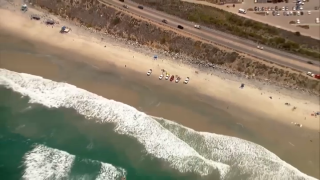 Rescue crews search for a possible missing swimmer off Torrey Pines State Beach, June 21, 2022.