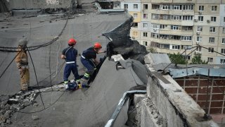 Ukrainian rescuers dismantle the roof of a high-rise building
