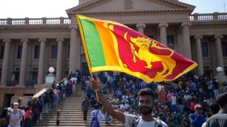 A protester waves a national flag outside president Gotabaya Rajapaksa's office