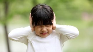 Image of child playing,girl have closed her ears