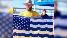 Mitch Silverstein, with the Surfrider Foundation in San Diego, stands with flag on the beach in this undated image.