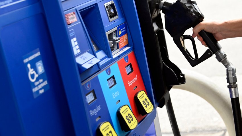 A person removes the nozel from a pump at a gas station on July 29, 2022 in Arlington, Virginia.