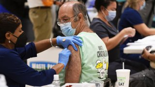 FILE - A nurse administers a COVID-19 booster shot at a vaccination site in Eastmonte Park, Altamonte Springs, Florida.