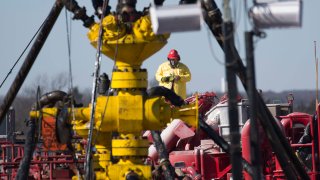 A Halliburton oil well fielder works on a well head at a fracking rig site January 27, 2016 near Stillwater, Oklahoma.