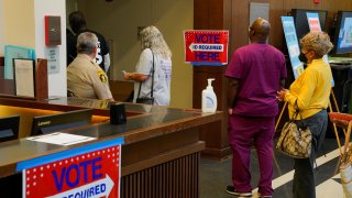 Voters file down the hall as early voting begins for the midterm elections at the Citizens Service Center in Columbus, Georgia, on Oct. 17, 2022.