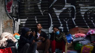 Venezuelan migrants wait for assistance outside of the Mexican Commission for Refugee Aid in Mexico City