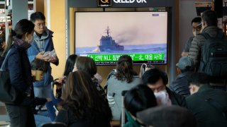 A TV screen shows a file image of a South Korean navy vessel