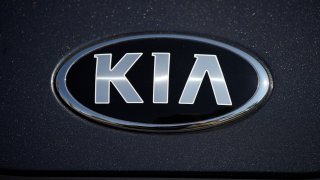 FILE โ The company logo shines off the hood of a 2021 K5 sedan on display in the Kia exhibit at the Denver auto show Friday, Sept. 17, 2021.