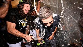 Mike Clevinger of the San Diego Padres (L) and San Diego Padres general manager A.J. Preller are doused with champagne after the Padres played the Chicago White Sox in a baseball game October 2, 2022 at Petco Park in San Diego.