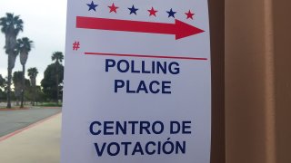A directional sign in English and Spanish indicates where to find a polling place.