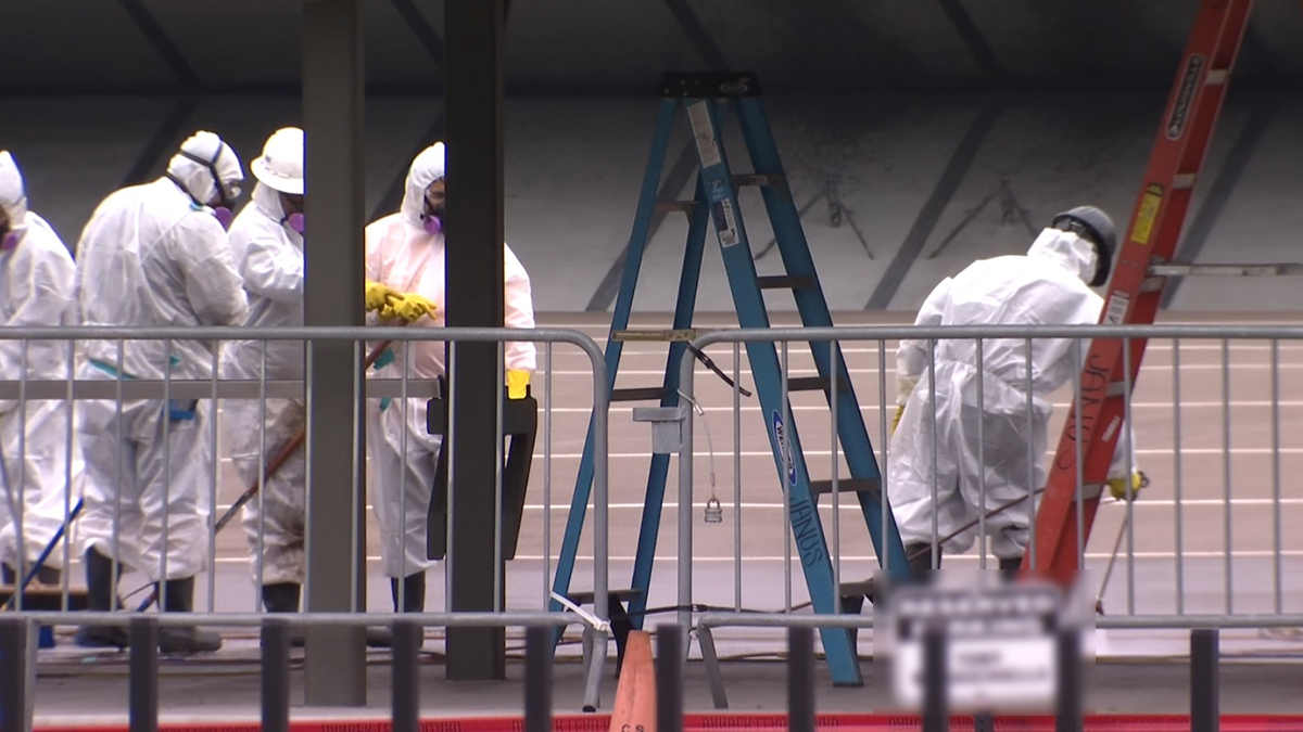 On October 13, 2022, lead abatement workers in hazmat suits work to remove lead dust from the San Diego Police Department's gun range.