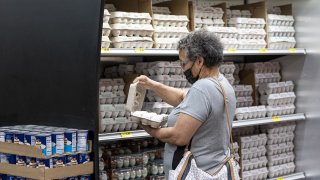 A shopper checks a carton of eggs at a San Francisco grocery store on May 2, 2022.